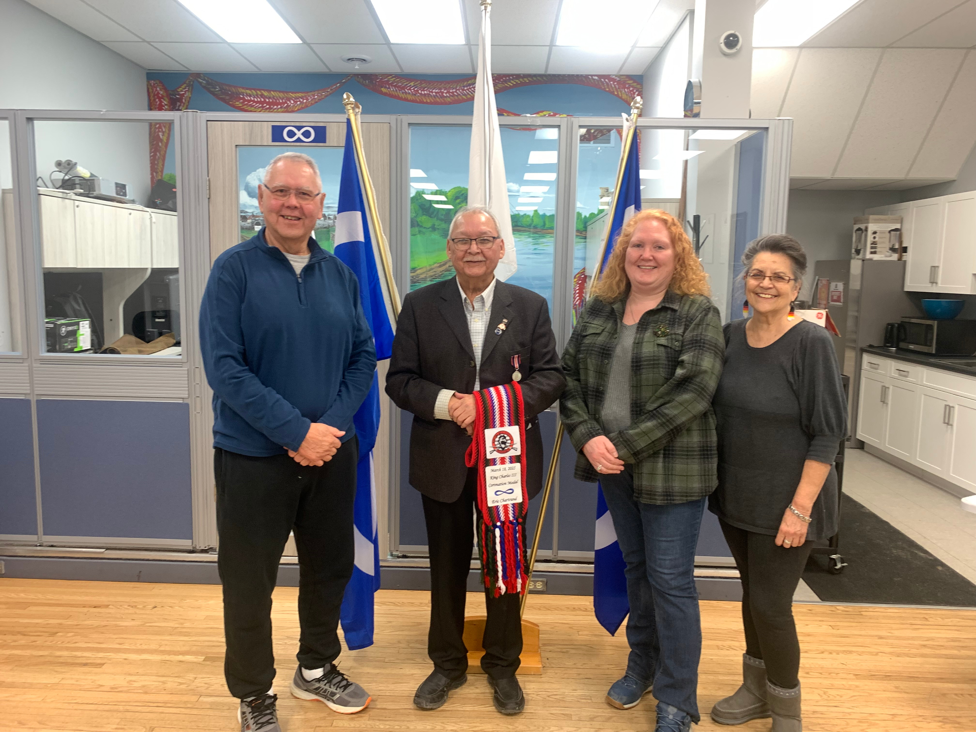 Community members standing together with Métis flags